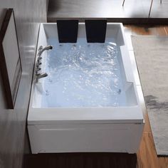 a white bath tub sitting on top of a wooden floor