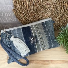 a small purse sitting on top of a wooden table next to a potted plant