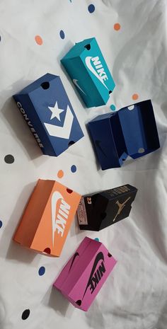 several different nike boxes are laying on a white sheet with polka dot paper around them