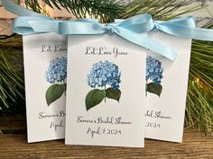 three blue hydrangeas are tied to tags