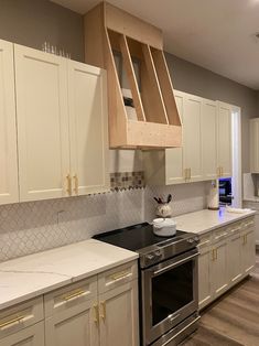 a kitchen with white cabinets and stainless steel appliances