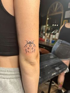 a lady bug tattoo on the left arm