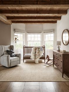 a baby's room with a crib, rocking chair and dresser in it