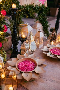 several plates with food on them are sitting on a table surrounded by candles and flowers