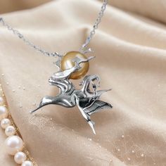 The silver necklace is adorned with a beautiful pendant featuring a subset and a crane, with the sun made of pearl. The pendant captures the essence of the ancient Chinese poem, "晓看天色暮看云，行也思君坐也思君", which can be translated as "At dawn, I gaze upon the sky; at dusk, I watch the clouds. Whether walking or sitting, I think of you, my love." The subset symbolizes the beauty of nature and the ever-changing sky. It serves as a reminder to appreciate the fleeting moments and the passage of time. The crane represents longevity, grace, and fidelity. Its presence adds elegance and a sense of tranquility to the necklace. At the center of the pendant, the sun made of pearl radiates a soft and gentle glow. The pearl symbolizes purity, wisdom, and prosperity. Its lustrous surface reflects light, evoking Silver Bird Design Pendant Necklace, Silver Bird Pendant Jewelry, Unique Bird Design Pendant Jewelry, Silver Jewelry With Bird Design, Elegant Bird Design Jewelry Gift, Elegant Bird Design Jewelry For Gift, Elegant Sterling Silver Necklace With Bird Design, Silver Bird-shaped Jewelry As Gift, Silver Bird-shaped Jewelry For Gift