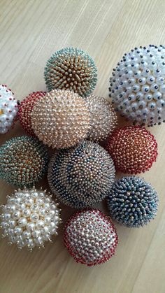 several different types of beaded balls on a wooden surface