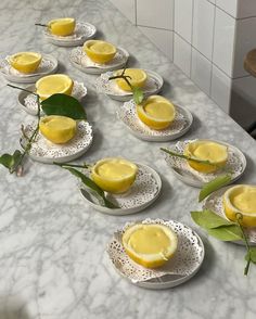 several plates with lemons on them sitting on a marble counter top in a kitchen