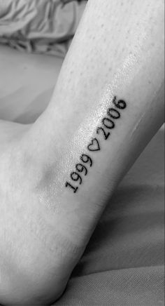 a person with a tattoo on their foot that reads, year 2009 written in cursive font