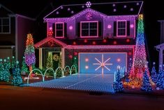 a house covered in christmas lights and trees