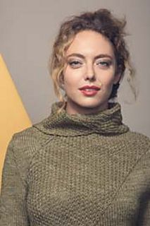 a woman wearing a green turtle neck sweater