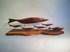 a group of wooden birds sitting on top of a piece of wood