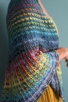 a woman wearing a multicolored knitted shawl over her head and shoulders