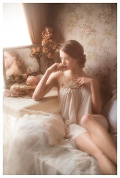 a woman sitting on top of a bed next to a mirror