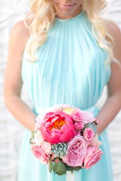 a woman in a blue dress holding a bouquet of flowers