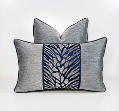 two blue and white pillows sitting next to each other