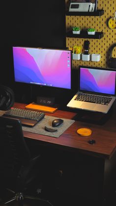 two laptops and a desktop computer sitting on a desk in front of a wall