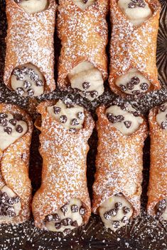 chocolate covered croissants with powdered sugar on top and sprinkles in the middle