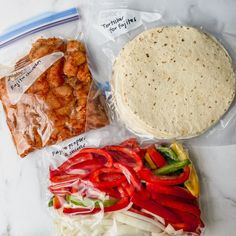 there are several different types of food in the bag on the counter top, including tortillas and peppers