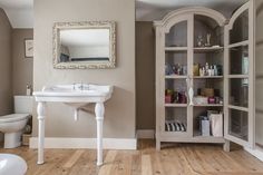 a white sink sitting next to a toilet in a bathroom