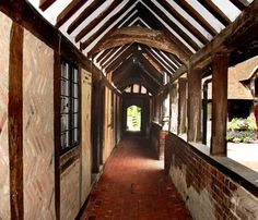 an open doorway leading into a building with wooden floors and walls, along with brick walkways