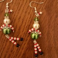 two christmas themed earrings on a wooden table