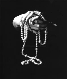 black and white photograph of hands holding beads