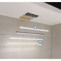 some lights hanging from the ceiling in a room with concrete walls and white tile flooring