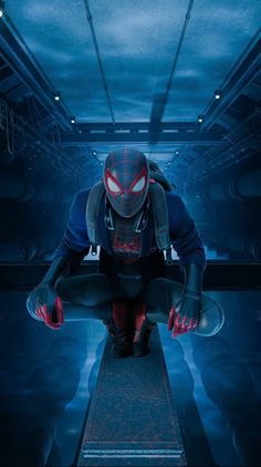 a man in a spider - man suit crouches down with his hands on his knees