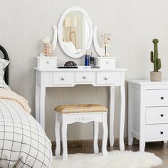 a white dressing table with a mirror and stool