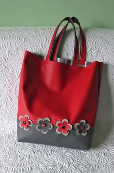 a red and gray purse with flowers on it