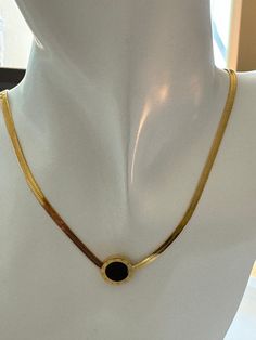 The Luminous Onyx Elegance necklace exudes sophistication. Its delicate gold chain cradles a circular pendant, mysterious and dark as midnight. Within its obsidian heart lies the allure of hidden constellations. Wear it as a celestial whisper against your skin, a reminder that even in darkness, there is beauty. Elegant Black Enamel Round Pendant Jewelry, Elegant Round Pendant Necklace With Black Enamel, Black Dainty Metal Jewelry, Dainty Black Metal Jewelry, Gold Onyx Pendant Jewelry, Black Jewelry With Delicate Round Chain, Black Jewelry With Delicate Chain, Gold Onyx Jewelry For Gift, Gold Round Necklace With Black Enamel