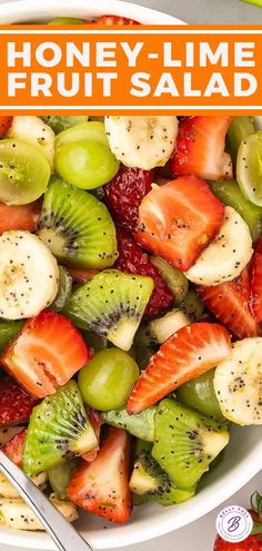 a white bowl filled with fruit salad on top of a table next to sliced strawberries and kiwis