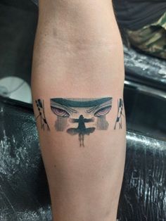 a tattoo on the leg of a person with an evil face and wings in front of them