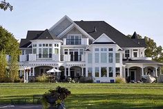 a large white house sitting on top of a lush green field