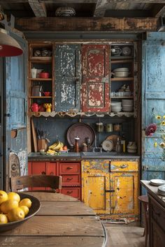 an old fashioned kitchen with blue cabinets and yellow lemons in the bowl on the table