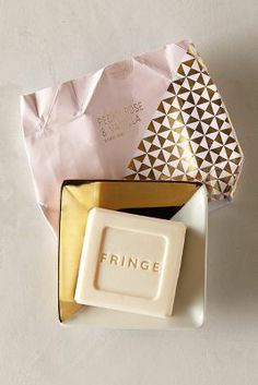 a soap bar sitting in a box next to a piece of paper with the word fringe printed on it