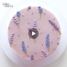 a pink cake with purple flowers on it