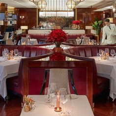 a dining room with tables and chairs covered in white tablecloths