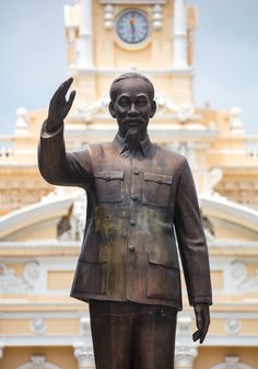 a statue of a man in front of a clock tower