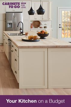 a kitchen with white cabinets and an island in the middle that has food on it