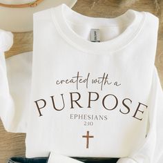 "Created with a Purpose Ephesians 2:10 Crewneck Sweatshirt Inspirational Christian Apparel Comfortable Stylish Faith-Inspired Clothing Gifts Embrace your faith with our \"Created with a Purpose Ephesians 2:10\" crewneck sweatshirt, a stylish and comfortable addition to your Christian apparel collection. This sweatshirt serves as a constant reminder of Ephesians 2:10, which reminds us that we are God's handiwork, created with a purpose. 🌟 Product Features: High-quality crewneck sweatshirt made f Faith Based Apparel, Ephesians 2:10, Jesus Shirts Christian Clothing, Created With A Purpose, Christian Products, Jesus Clothes, Christian Shirts Designs, Printed Gifts, Ephesians 2