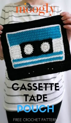 a woman holding up a crocheted bag with an image of a cassette tape on it