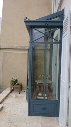 a small patio with a table and chairs next to a building on the side walk