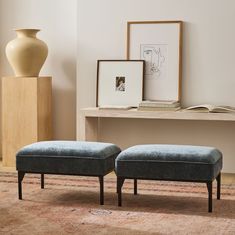 two blue ottomans sitting on top of a rug in front of a wooden table