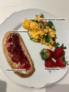 a white plate topped with eggs, toast and strawberries