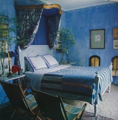 a bedroom with blue walls and curtains on the windowsills is pictured in this image