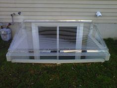 an air conditioner sitting in the grass next to a house