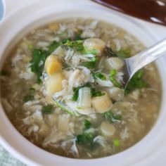 a white bowl filled with soup next to a spoon