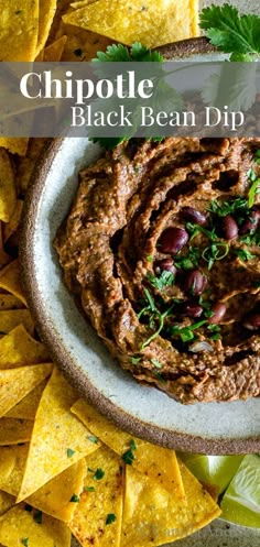 a bowl filled with black bean dip surrounded by tortilla chips and cilantro