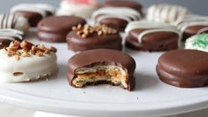 chocolate covered desserts are on a white platter